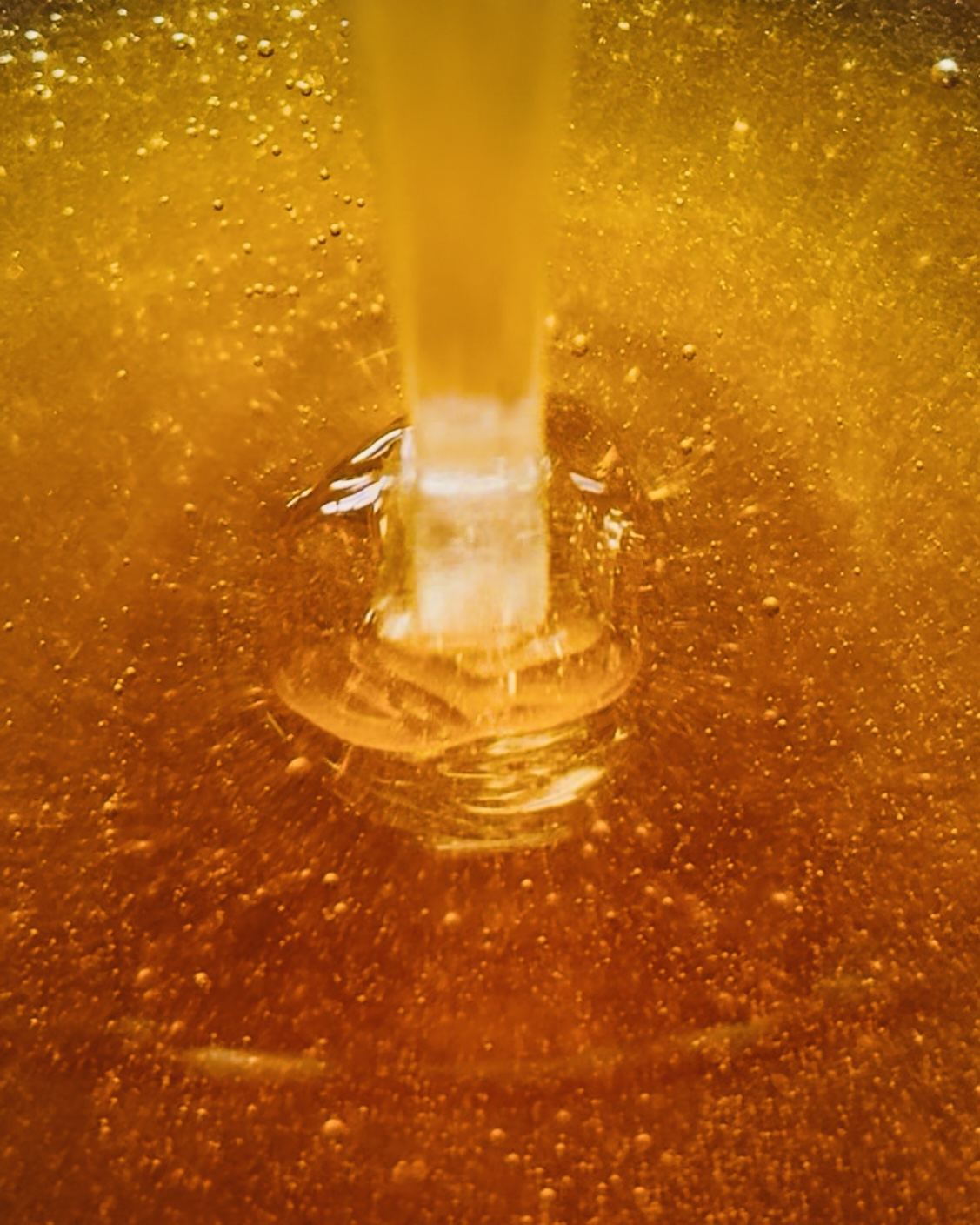 Frischer Honig fließt langsam und goldfarben in Nahaufnahme